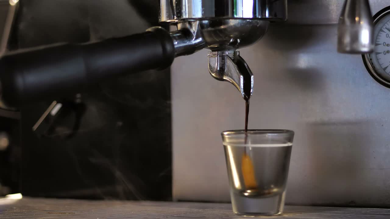 Frissen készülő eszpresszó egy kávégép mellett